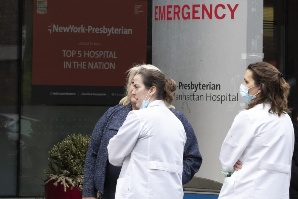 Medical personnel talk outside the emergency room at NewYork-Presbyterian Lower Manhattan Hospital, Wednesday, March 18, 2020, in New York. (Mary Altaffer/AP)