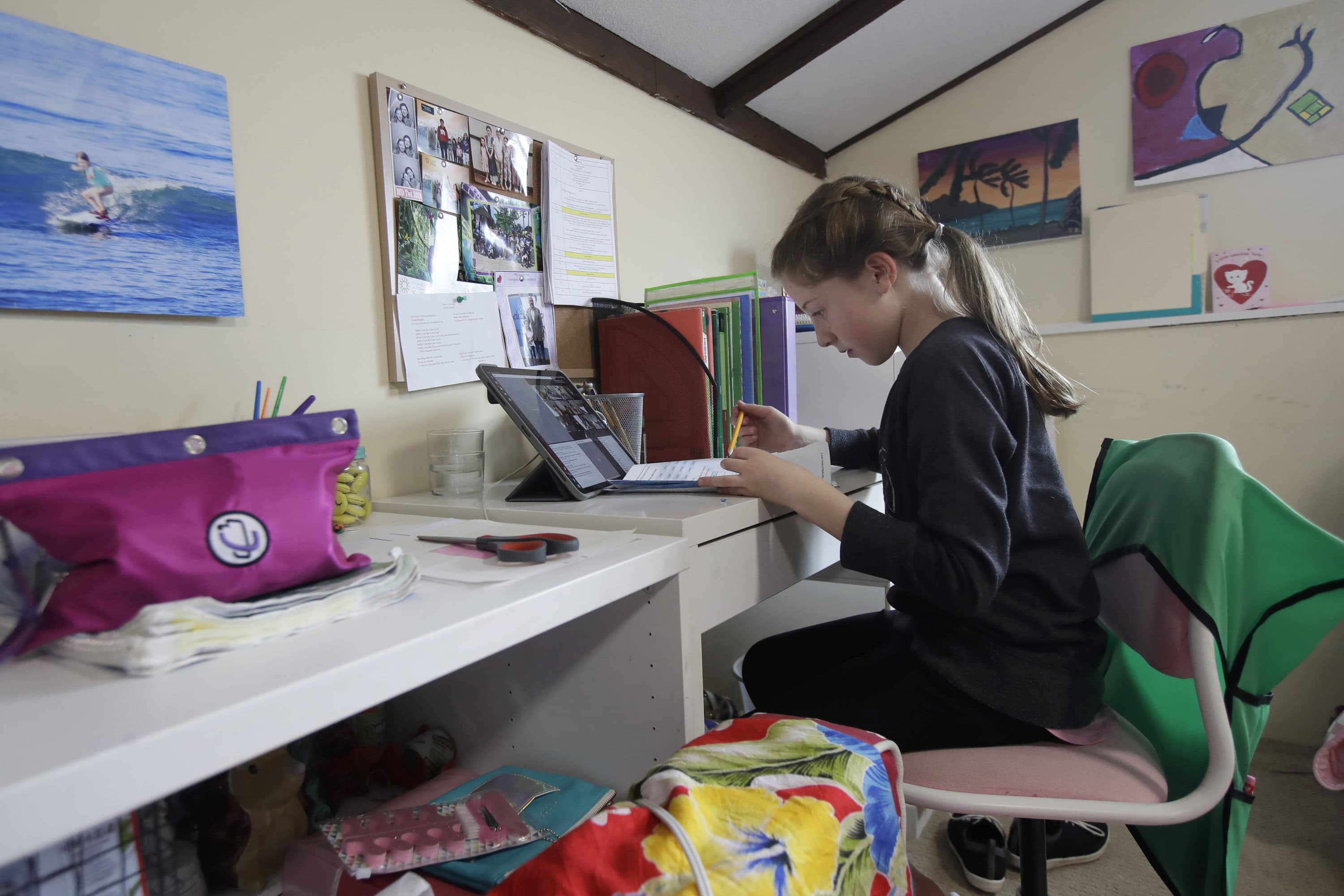 In this Thursday, March 19, 2020, photo, Rachel Keenan, 9, takes a live class online at her home in San Francisco. California's Bay Area has been shut down for more than a week, the first region of America to order its residents to stay home, work remotely and homeschool their children in a desperate bid to slow the spread of the coronavirus pandemic. (Jeff Chiu/AP)