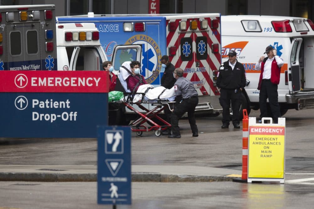 An ambulance crew transports a patient at the Massachusetts General Hospital emergency entrance, Friday, April 3, 2020, in Boston. (Michael Dwyer/AP)