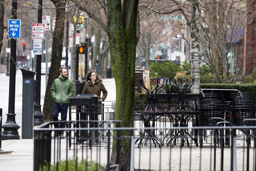 A couple walks past closed businesses on Newbury Street, Saturday, April 4, 2020, in Boston..The new coronavirus causes mild or moderate symptoms for most people, but for some, especially older adults and people with existing health problems, it can cause more severe illness or death. (AP Photo/Michael Dwyer)