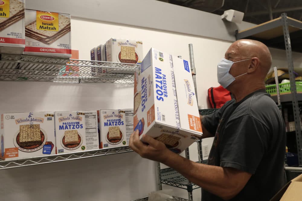 Volunteer Marty Heiman loads Passover Matzos onto a shelf at the Jewish Community Services Kosher Food Bank during the new coronavirus pandemic, April 8, 2020, in North Miami Beach, Fla. (Lynne Sladky/AP)