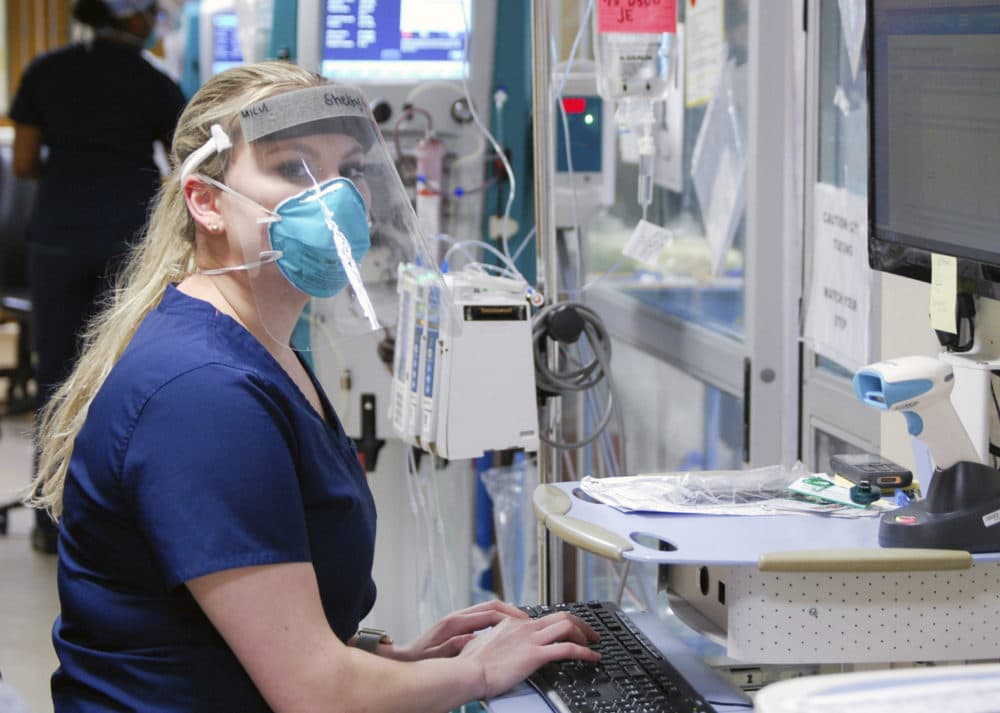 In this Wednesday, April 8, 2020 photo provided. by UAB Hospital, intensive care nurse Shelby Roberts, who helped a family say goodbye to a woman dying of COVID-19 at UAB Hospital in Birmingham, Ala., works in protective gear. (Amanda Chambers/UAB Hospital via AP)