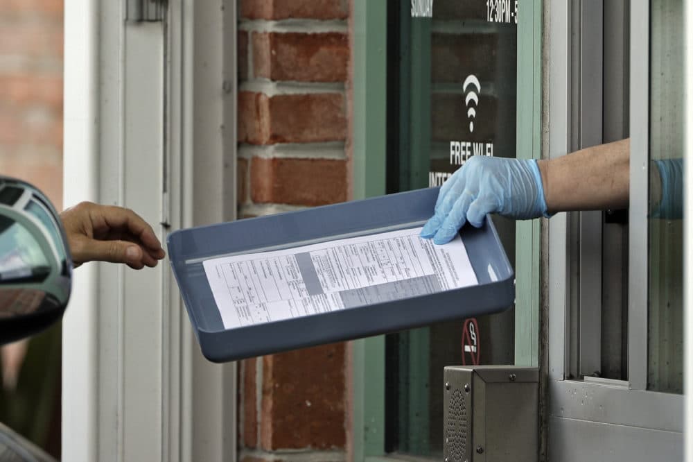 A library employee hands unemployment paperwork to residents at the Jimmie B. Keel Regional Public Library in Tampa, Fla. Most states have started to provide the extra jobless aid, though many did so only this week. (Chris O'Meara/AP File Photo)