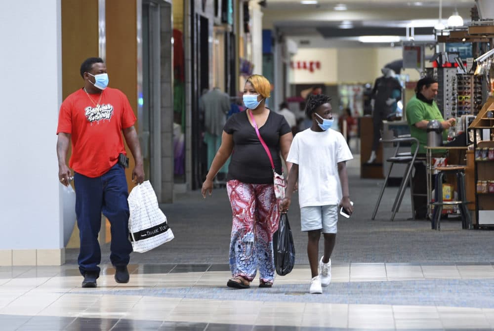 Ronnie Johnson, left, Gwen Evans, center, and Jamarion Davis shop while wearing masks to protect against coronavirus, after the Anderson Mall opened to limited business, Friday, April 24 2020 in Anderson, S.C. (Richard Shiro/AP Photo)