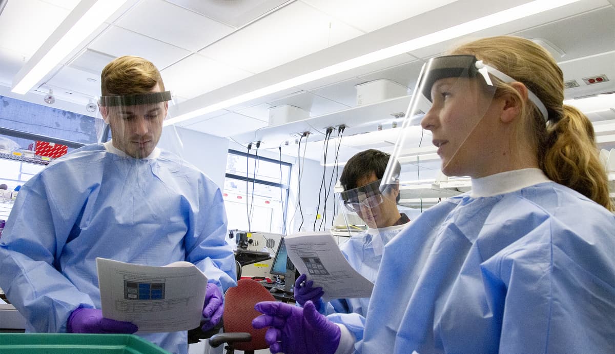 Michelle Cipicchio (right), process development manager on the Broad Institute's Genomics Platform R&D team, trains two lab technicians to extract viral RNA from patient samples. (Scott Sassone/Broad Institute)
