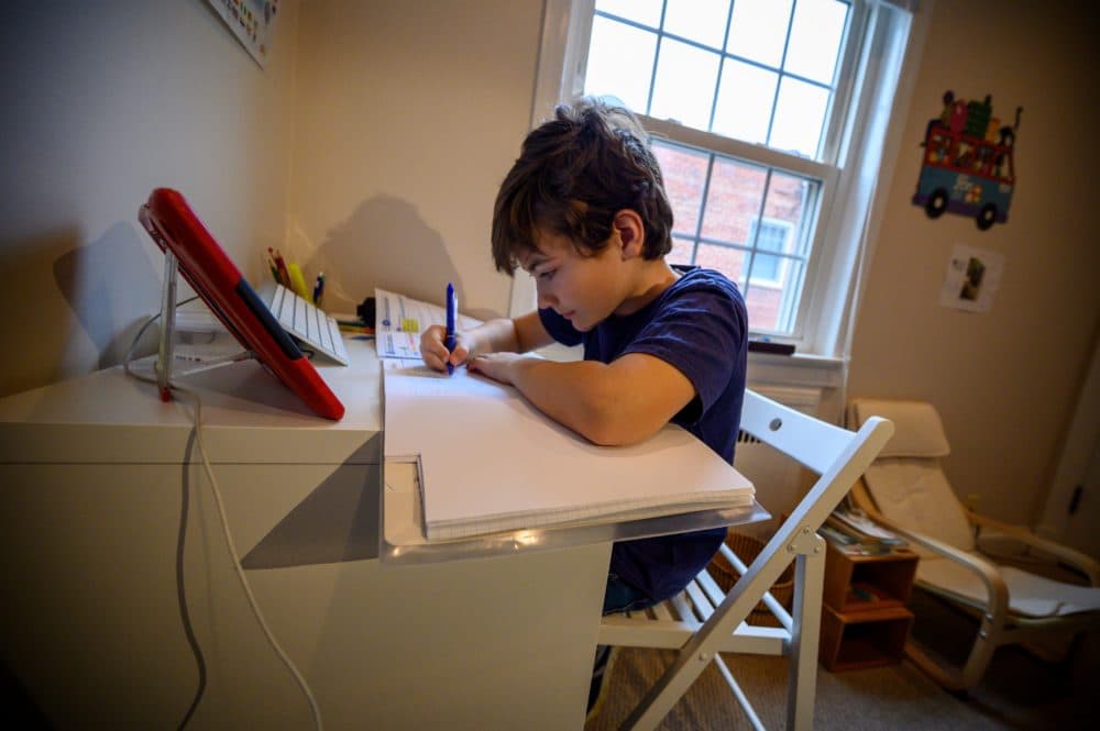 Colin, 10, whose school was closed following the coronavirus outbreak, does school exercises at home in Washington on March 20, 2020. (ERIC BARADAT/AFP via Getty Images)