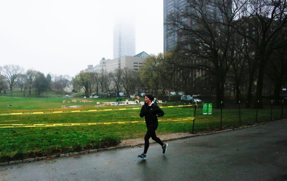 A woman jogs by Central Park as workers set up a field hospital in front of Mount Sinai West Hospital on March 29, 2020 in New York City. (KENA BETANCUR/AFP via Getty Images)