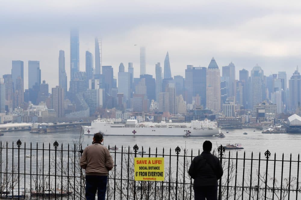 People watch as the USNS Comfort medical ship moves up the Hudson River as it arrives on March 30, 2020 in New York as seen from Weehawken, New Jersey. (ANGELA WEISS/AFP via Getty Images)