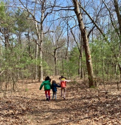The author's daughters frolic in the woods while out for a pandemic nature walk. (Cloe Axelson)