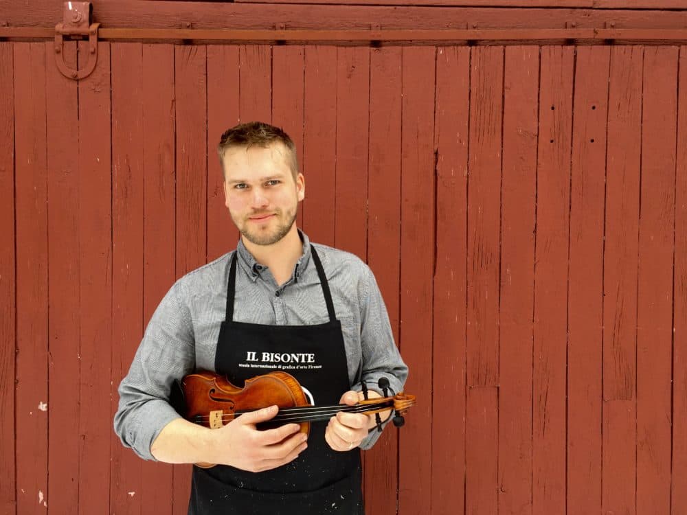Luthier Jacob Brillhart holding one of the violins he made. (Courtesy Aneleisa Gladding-Hinton)