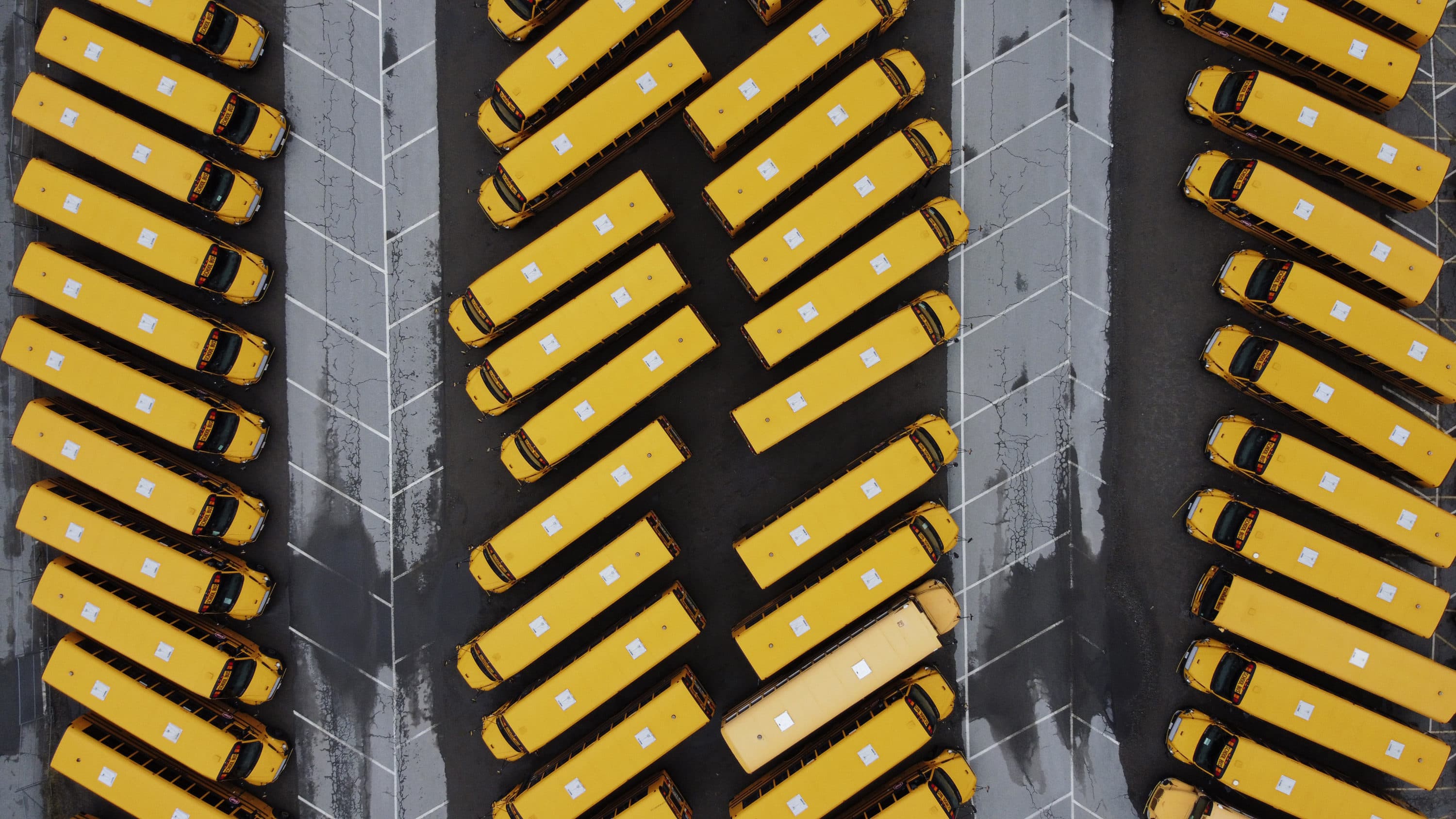 School buses sit parked in a lot as schools remain closed due to the coronavirus on March 30 in Providence, R.I. (David Goldman/AP)