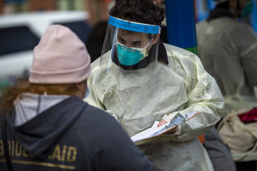 A Massachusetts General Hospital researcher registers the name of a Chelsea resident at a pop-up testing site in Bellingham Square. (Jesse Costa/WBUR)