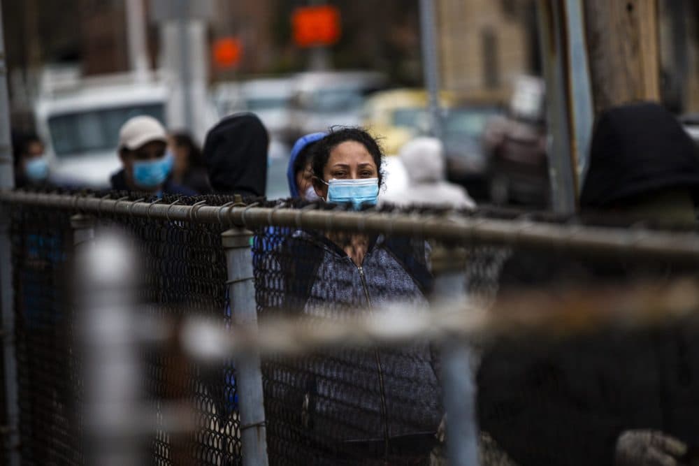 A woman waits in line for food at the Salvation Army in Chelsea. The line extended down Chestnut Street. (Jesse Costa/WBUR)
