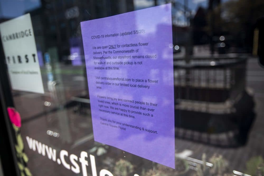 A sign in the window of Central Square Florist in Cambridge, informs customers of their new operating procedures, now that the COVID-19 restrictions for some non-essential businesses in Massachusetts have been lifted, including florists. (Jesse Costa/WBUR)