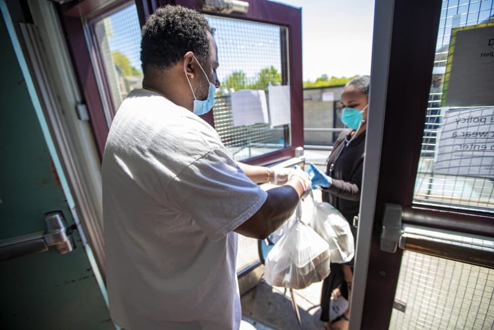 Youth meals being distributed at the front door of the Hennigan Community Center in Jamaica Plain. (Jesse Costa/WBUR)