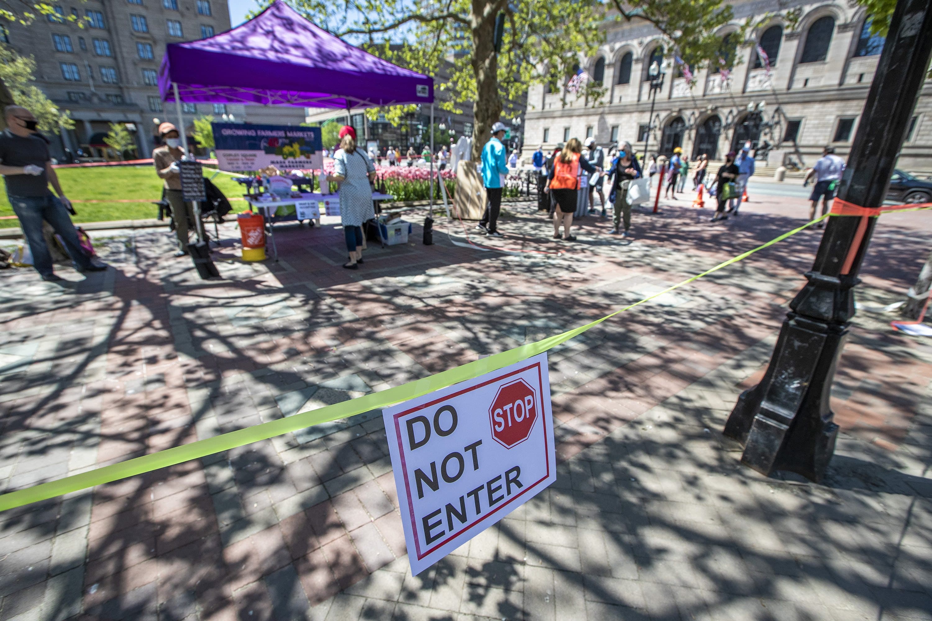 Caution tape surrounds the perimeter of the Copley Square Farmers Market, to keep people entering and exiting through one way, as it got under way Friday. (Jesse Costa/WBUR)