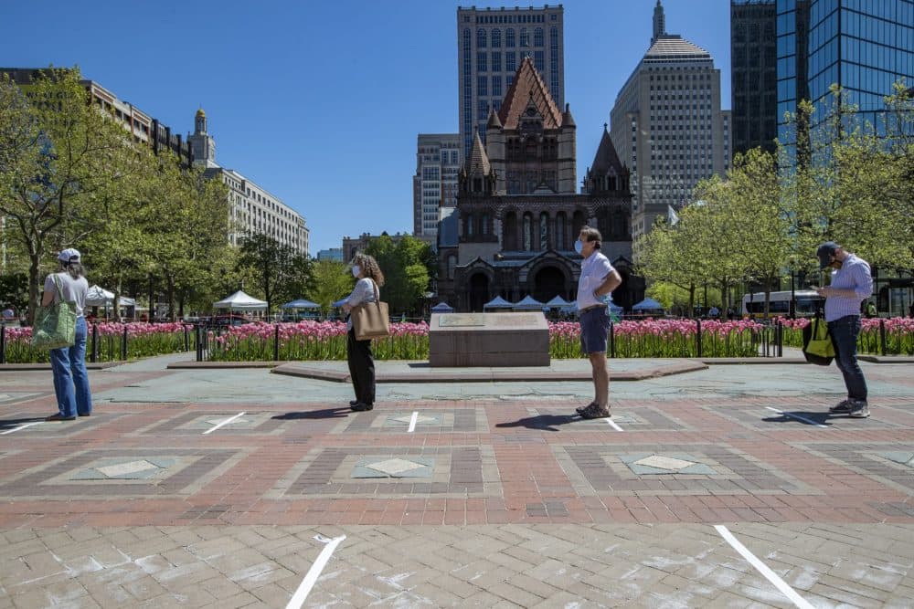 People stand in line, at least six-feet apart, to enter the Copley Square Farmers Market. (Jesse Costa/WBUR)