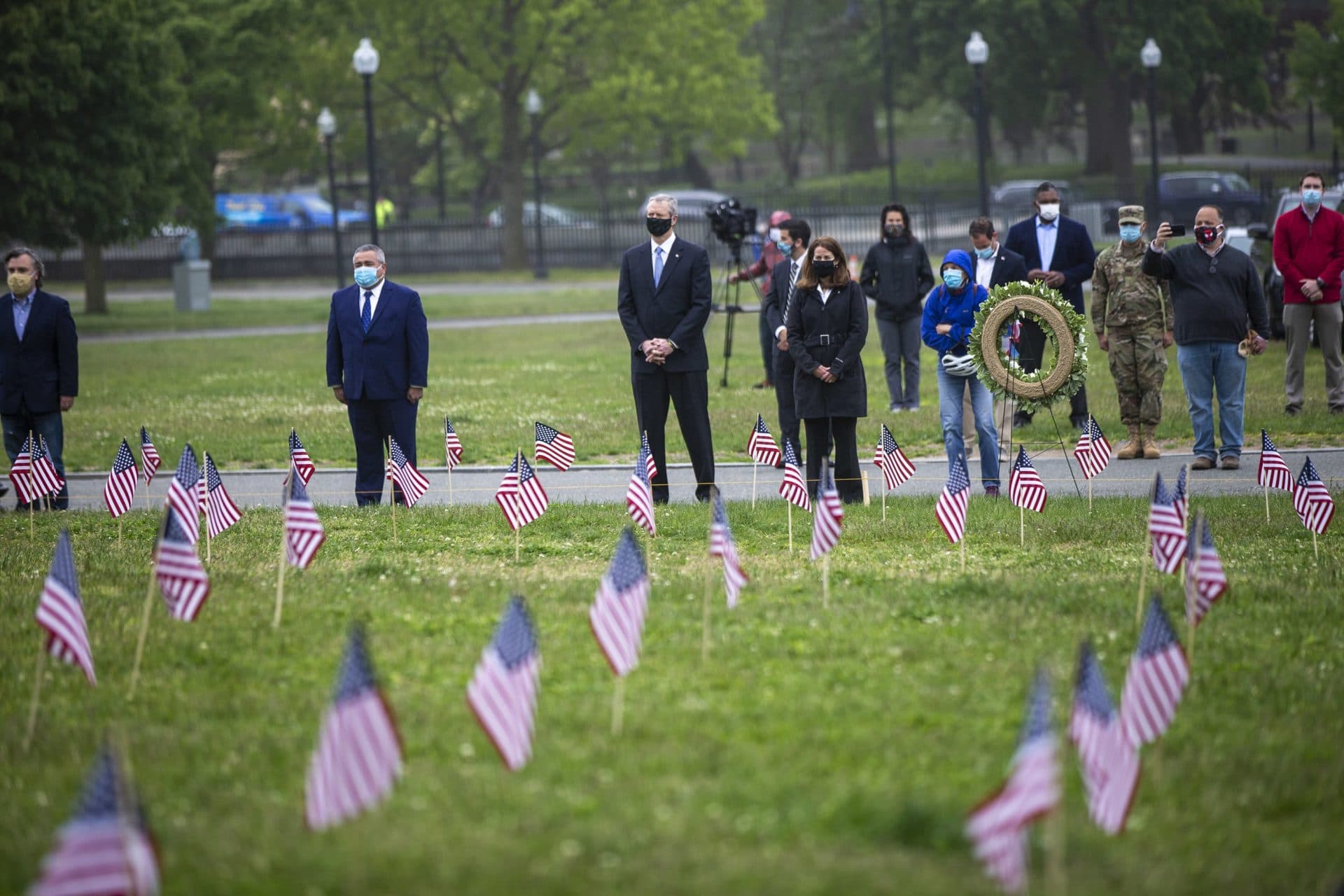 Gov. Charlie Baker and members of the Massachusetts Military Heroes Fund stand during a moment of silence after a wreath was placed in the Boston Common to honor Massachusetts veterans who died during military action. (Jesse Costa/WBUR)