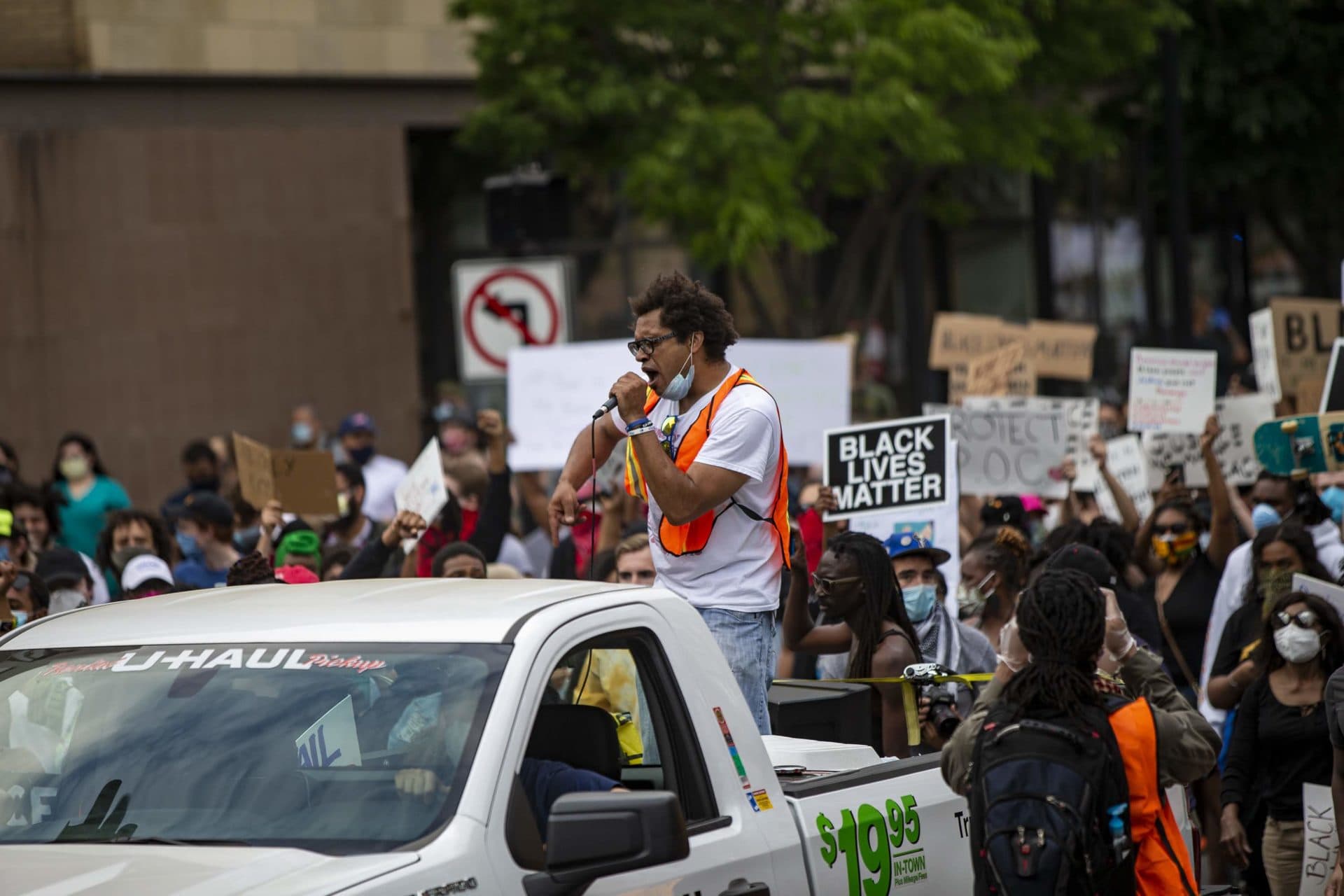 In the back of a rental pickup, Brock Satter leads about one thousand protesters down Washington Street in Boston in outrage over the killing of George Floyd among other protests nationwide. (Jesse Costa/WBUR)