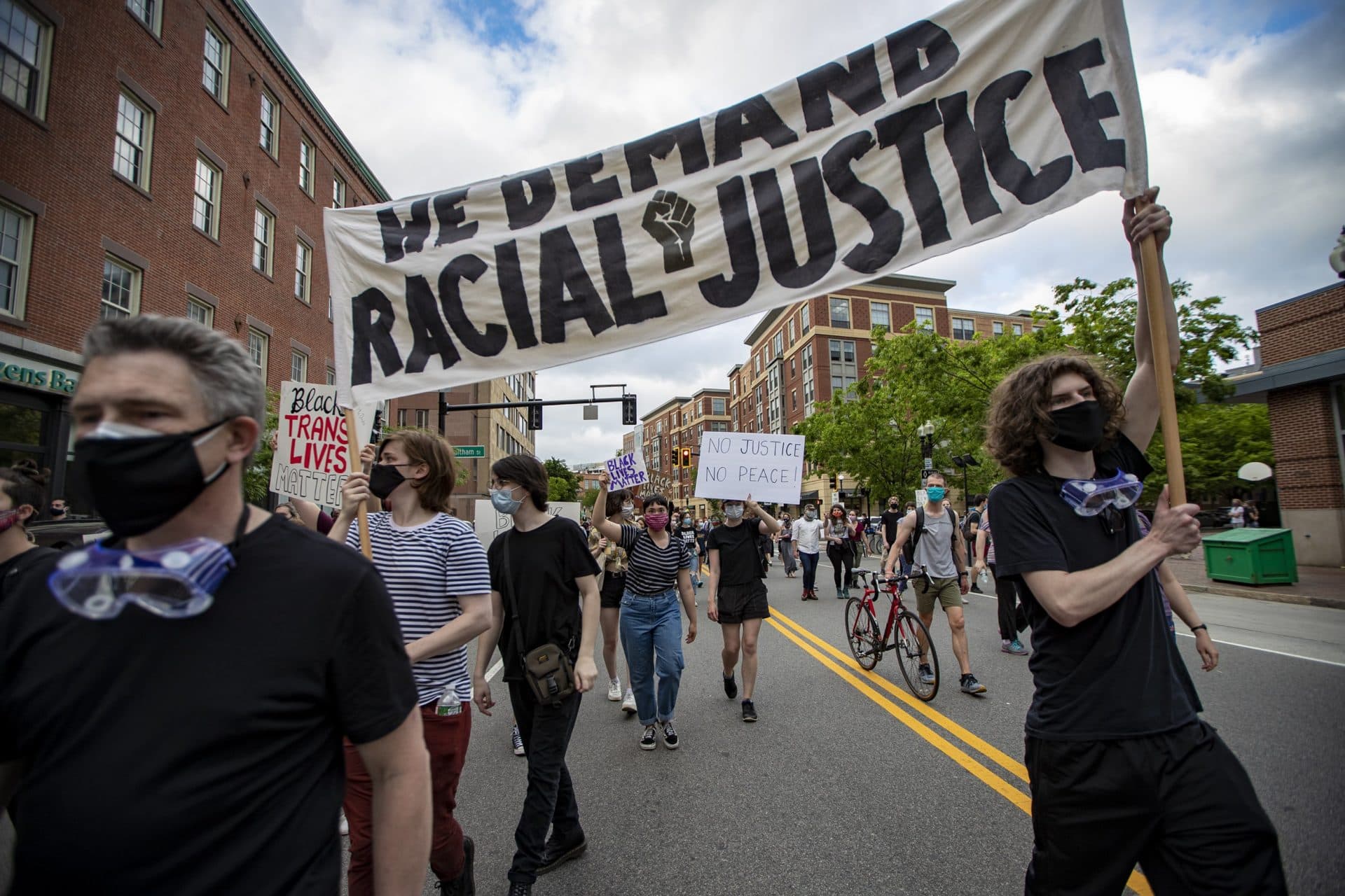 Protesters hold a banner as they march down Washington Street in Boston. (Jesse Costa/WBUR)