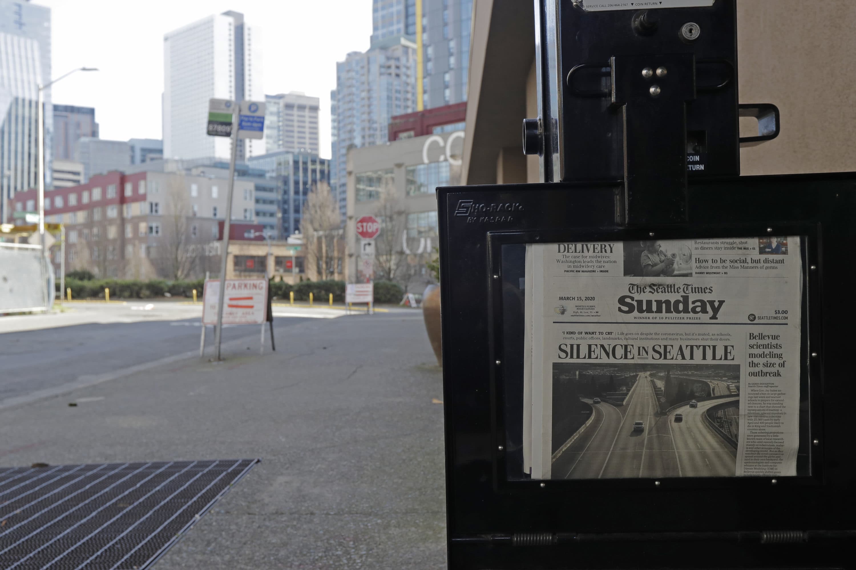 The street next to a Seattle Times newspaper box in front of the building that houses the Times' newsroom is empty, Sunday, March 15, 2020 in Seattle, as the headline "Silence in Seattle" is displayed. (Ted S. Warren/AP Photo)