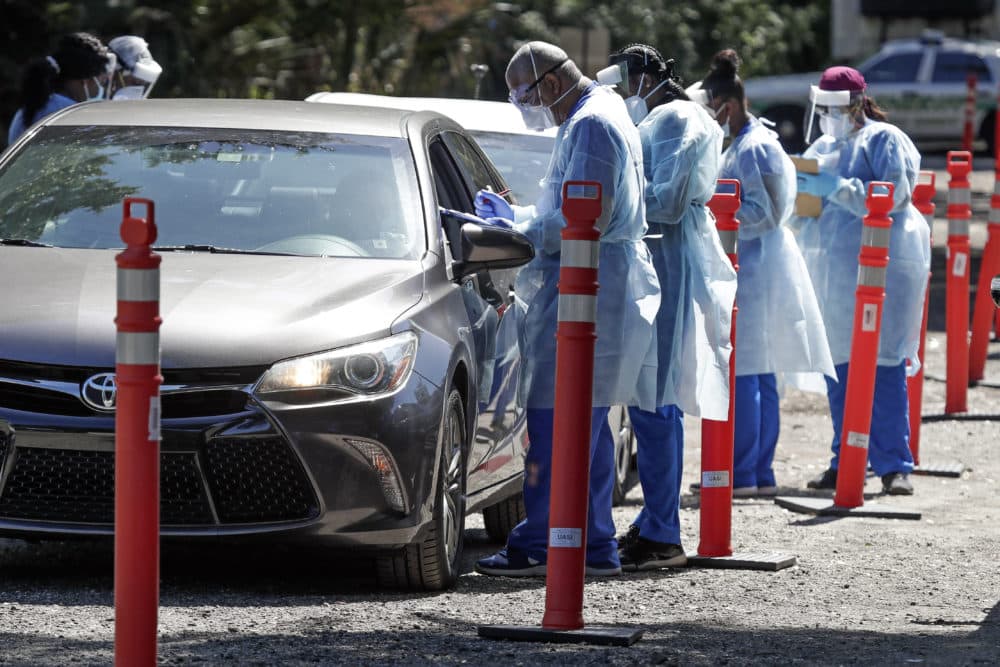 Health workers conduct COVID-19 tests at a drive through coronavirus testing site at a community center Monday, April 27, 2020, in Sanford, Fla. (John Raoux/AP)