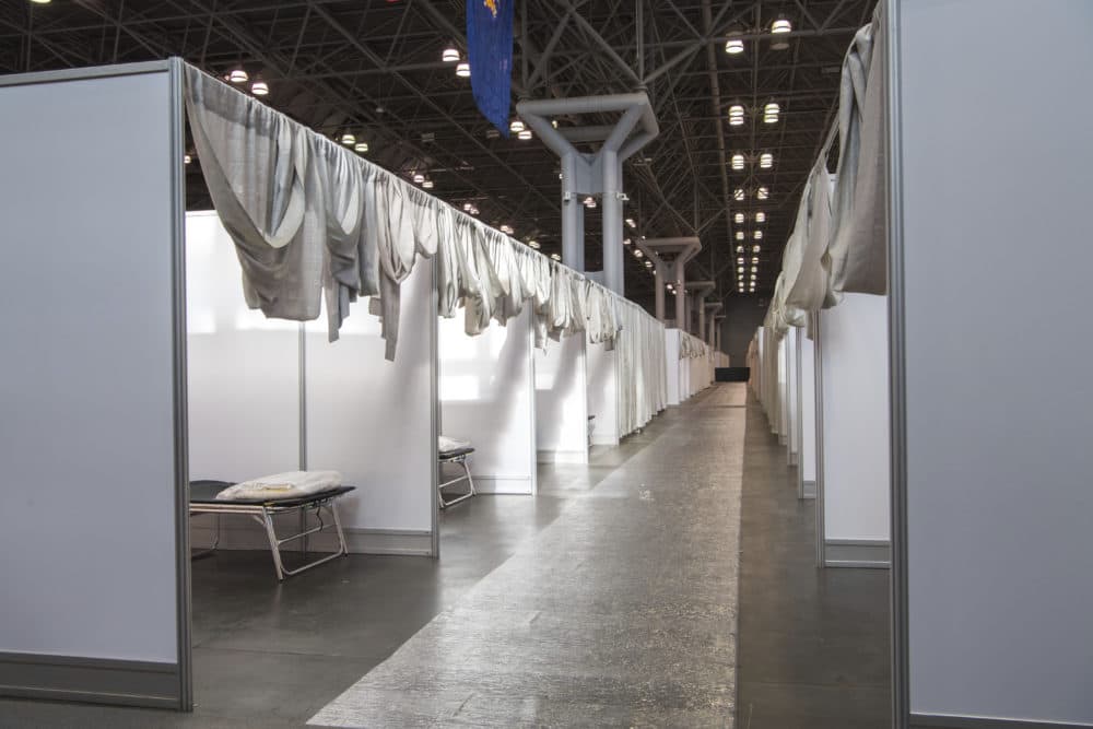In this Friday, March 27, 2020, photo provided by the office of Governor Andrew M. Cuomo, makeshift hospital rooms stretch out along the floor at the Jacob Javits Convention Center in New York. (Darren McGee/Office of Governor Andrew M. Cuomo via AP)