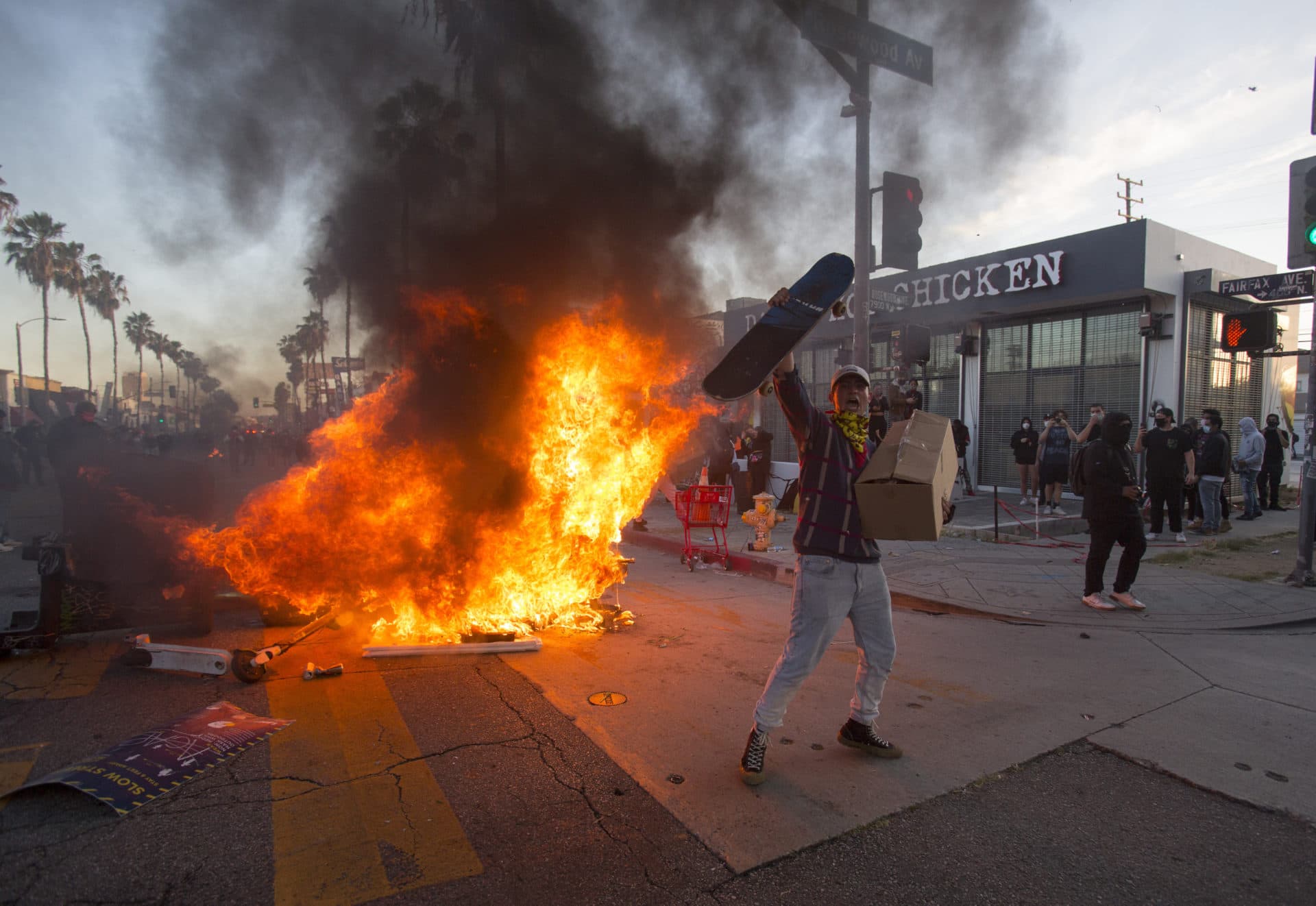 A protester shouts in front of a fire during an anti-police brutality protest over the death of George Floyd in Los Angeles on Saturday. (Ringo H.W. Chiu/AP)