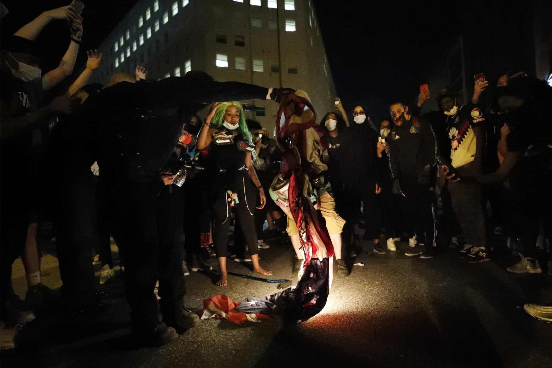 Demonstrators watch an American flag burn as people gather to protest the death of George Floyd, Sunday, May 31, 2020, near the White House in Washington. Floyd died after being restrained by Minneapolis police officers. (AP Photo/Alex Brandon)