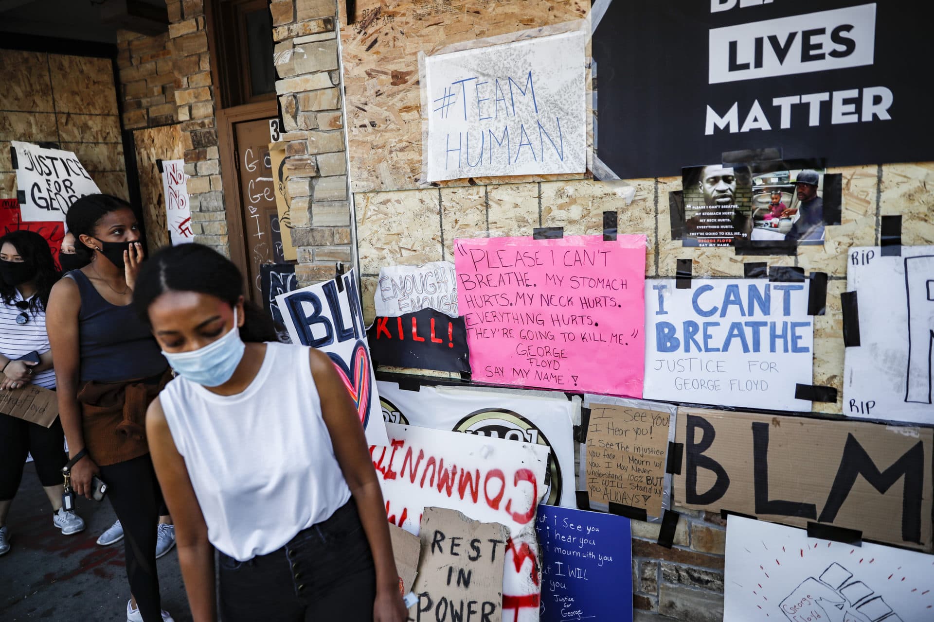 Mourners gather to place flowers at a makeshift memorial for George Floyd at the corner of Chicago Avenue and East 38th Street, Sunday, May 31, 2020, in Minneapolis. (AP Photo/John Minchillo)