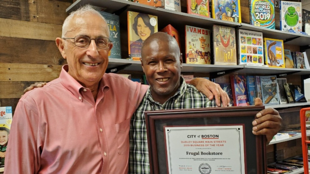Bob Romanow and Leonard Egerton pictured with the Frugal Bookstore's 2019 Business of the Year award from the City of Boston. (Courtesy)