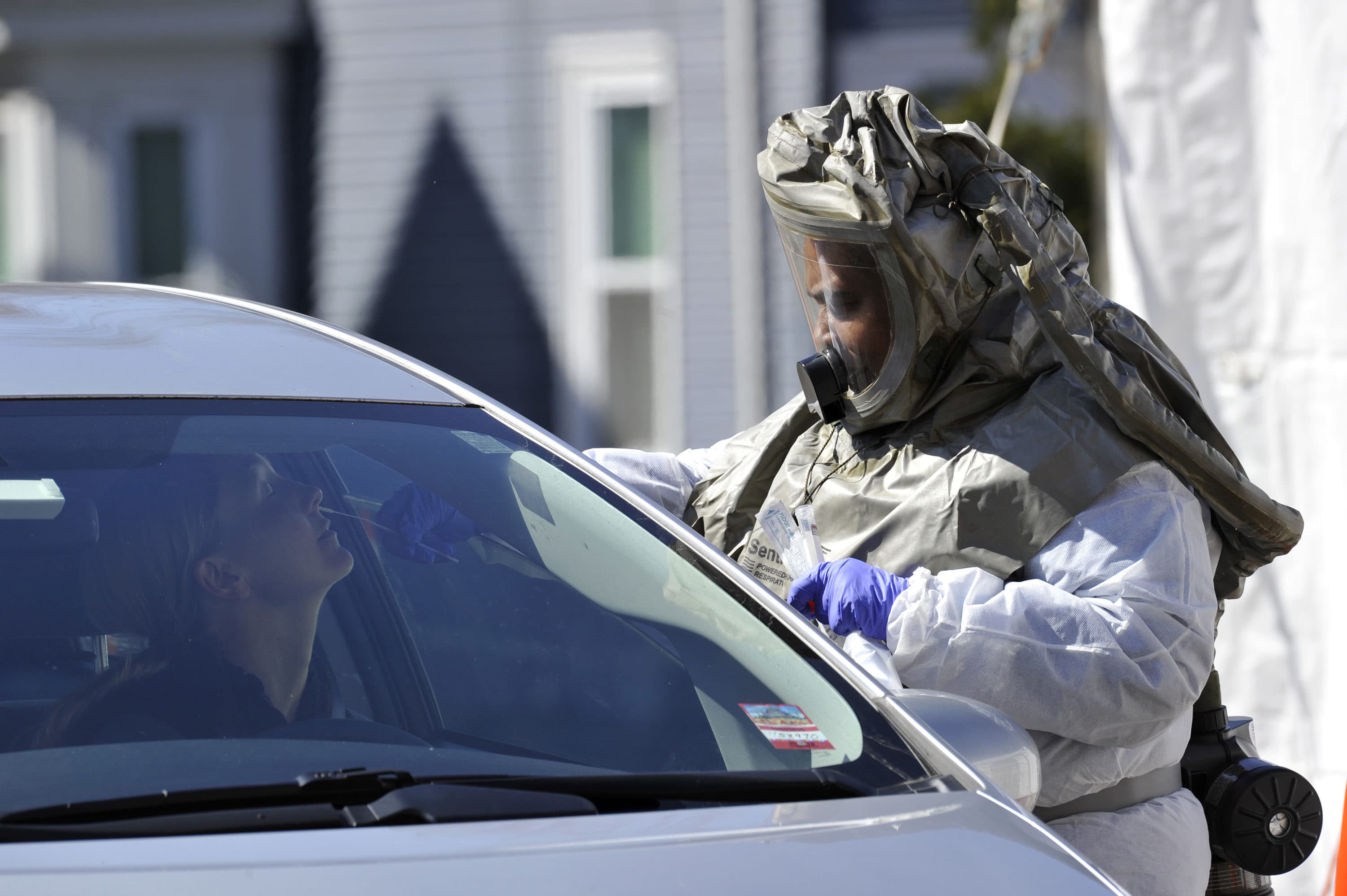 A medical personnel member takes samples of person at a "drive-thru" coronavirus testing lab set up at Somerville Hospital in Somerville, Massachusetts on March 18, 2020. (Joseph Prezioso/AFP via Getty Images)