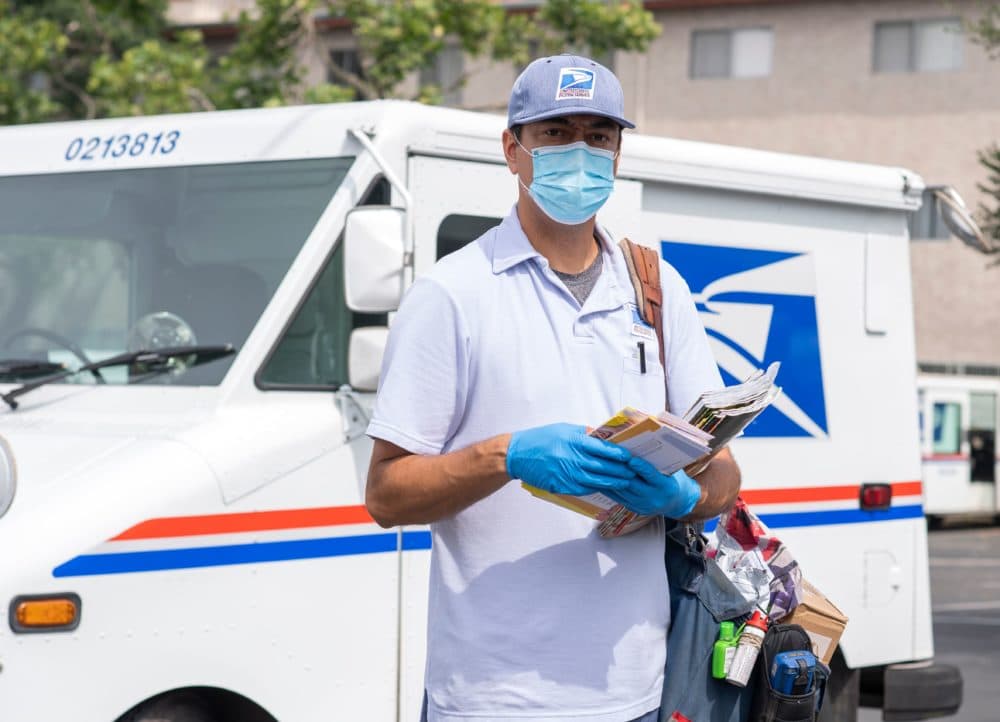 Mail carrier Oscar Osorio poses for a photo before going on his delivery route in Los Feliz amid the Covid 19 pandemic, April 29, 2020 in Los Angeles, California. (VALERIE MACON/AFP via Getty Images)