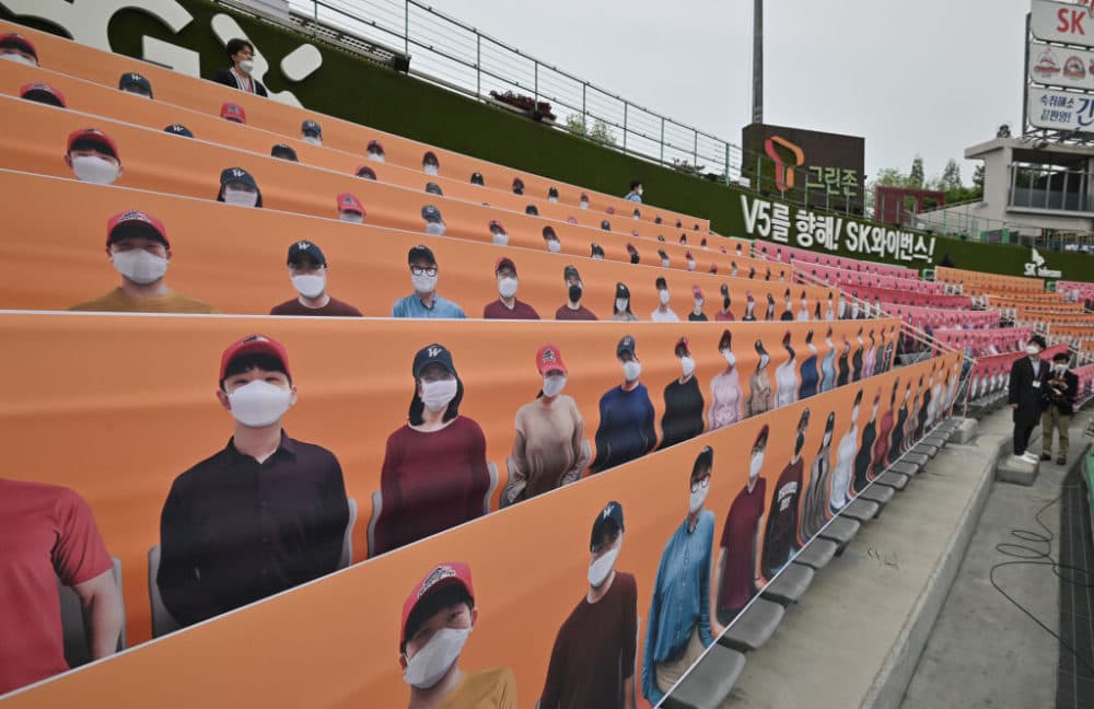 People walk past banners depicting spectators in the stands prior to South Korea's new baseball season opening game between SK Wyverns and Hanwha Eagles in Incheon on May 5, 2020. (Jung Yeon-je/AFP/Getty Images)