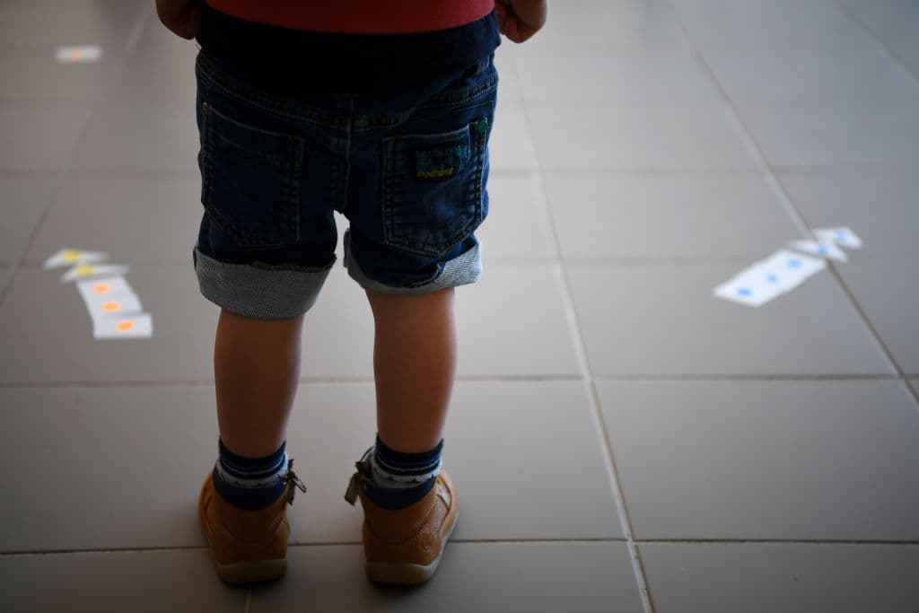 A boy stands near as he discovers glued-on arrows set up to mark social distancing measures at an elementary school a few days before its reopening in France. (Franck Fife/AFP/Getty Images)