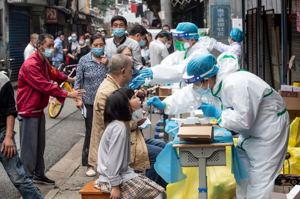 Medical workers take swab samples from residents to be tested for the COVID-19 coronavirus, in a street in Wuhan in China's central Hubei province on May 15, 2020. (STR/AFP via Getty Images)
