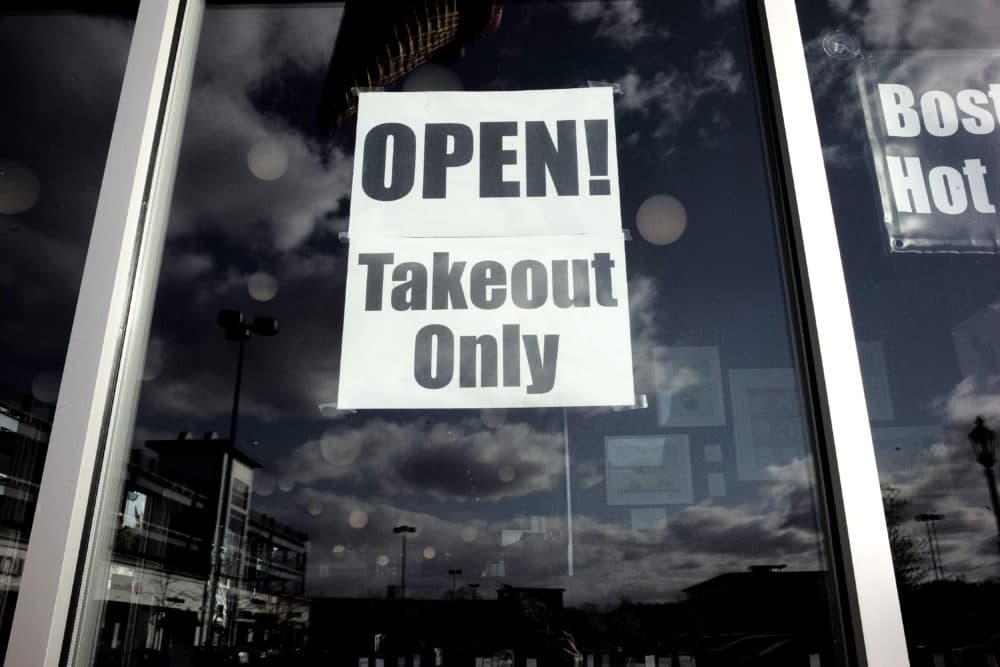 In this April 22 photo a sign advises customers that a restaurant is offering takeout only out of concern for the coronavirus in an outdoor mall in Dedham, Mass. (Steven Senne/AP)
