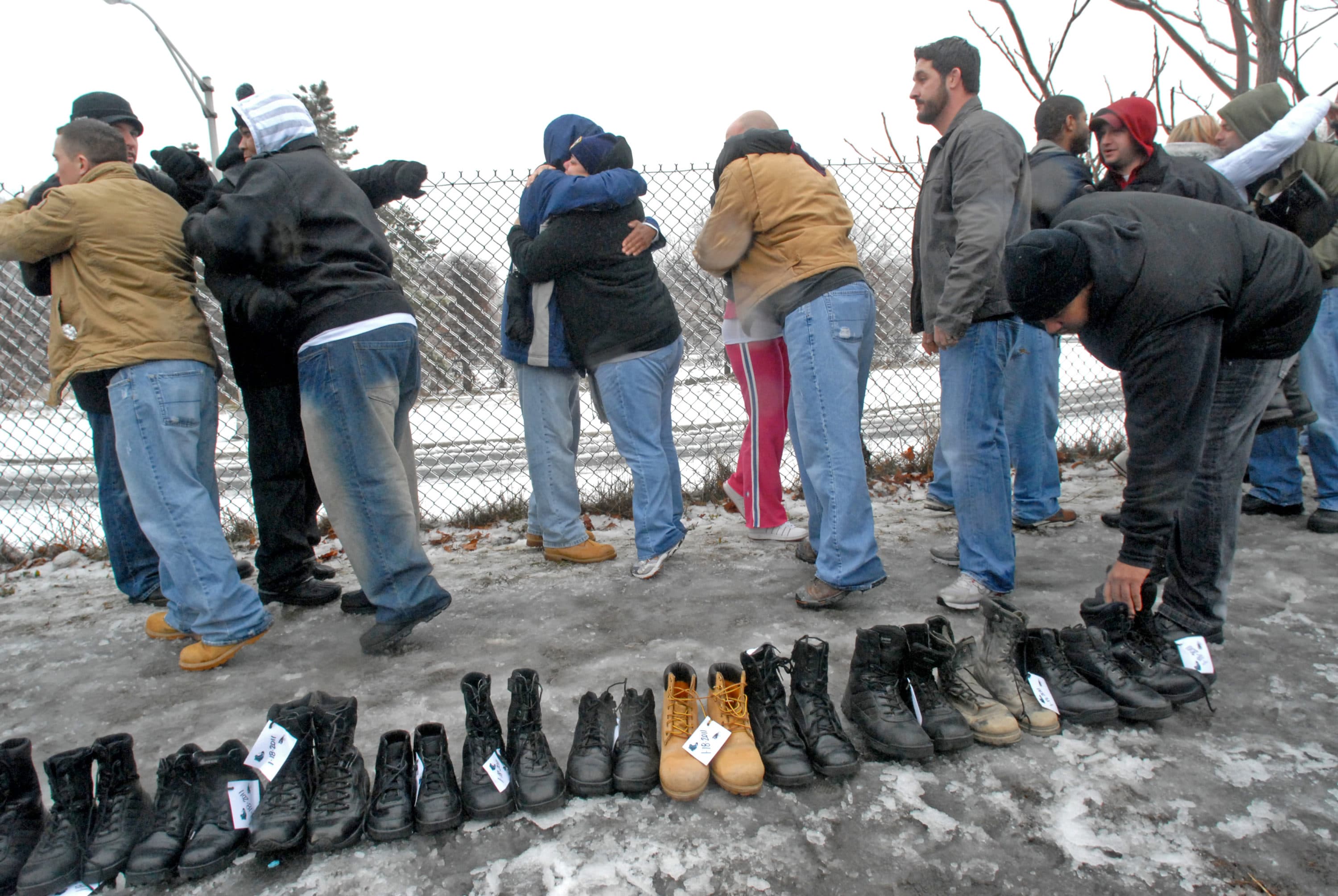 On January 18, 2011, Camden police officers embraced and placed their boots along an icy sidewalk after nearly half of them were laid off. (Photo by April Saul)