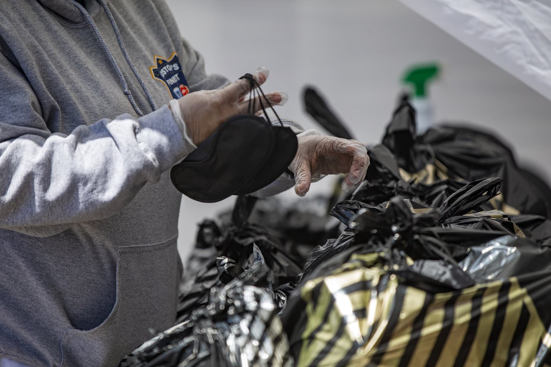 A Rosie's Place employee attaches face masks to the outside of grocery bags women will pick up at the food pantry