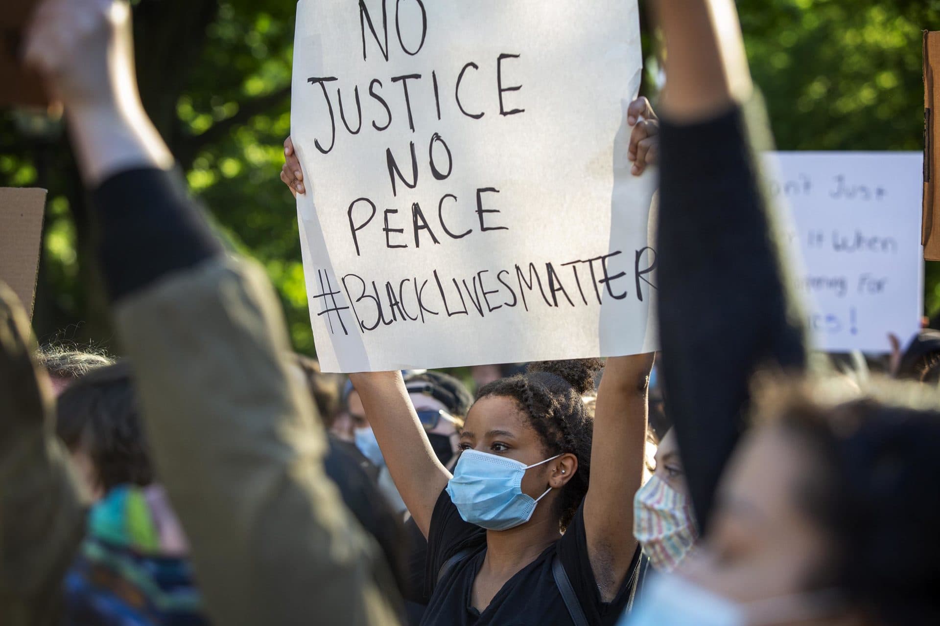 A Black Lives Matter protester hold up a banner on Boston Common. (Robin Lubbock/WBUR)