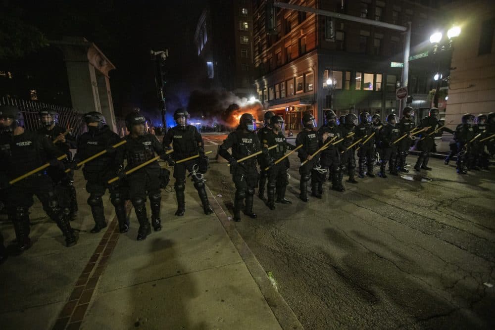 Boston Police line up on Tremont Street to after a police SUV had been set ablaze. (Jesse Costa/WBUR)