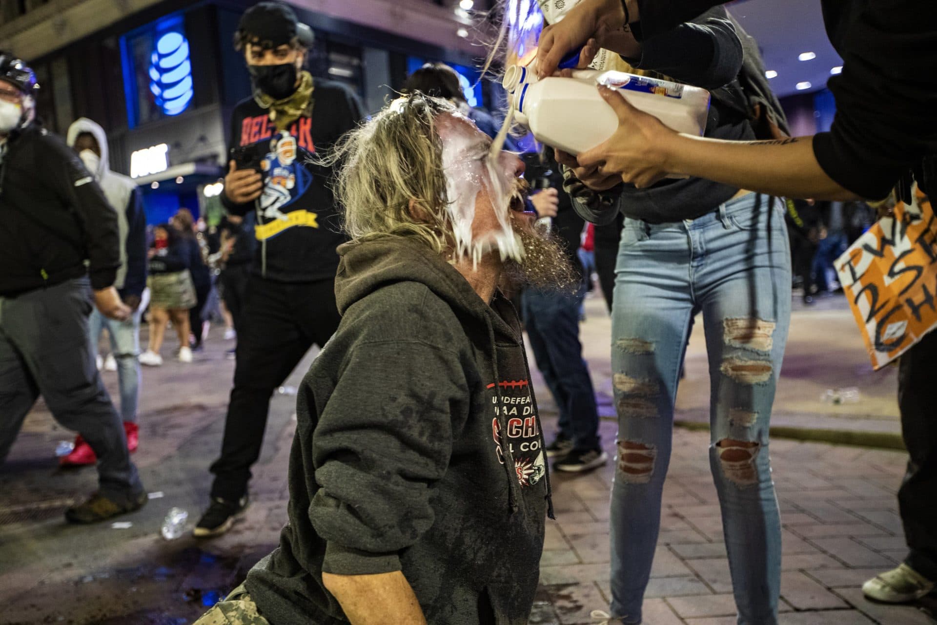 A man gets milk poured on his face after being pepper sprayed by Boston Police in Downtown Crossing. (Jesse Costa./WBUR)