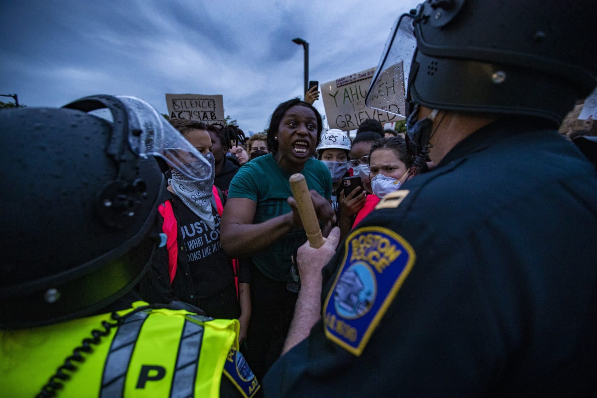 A protester speaks with a Boston Police officer in front of Forest Hills Station. (Jesse Costa/WBUR)