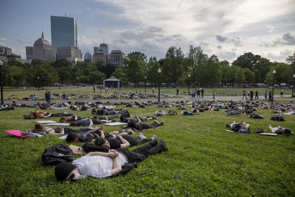 Protesters lie on Boston Common as if handcuffed during a protest on Wednesday. (Robin Lubbock/WBUR)
