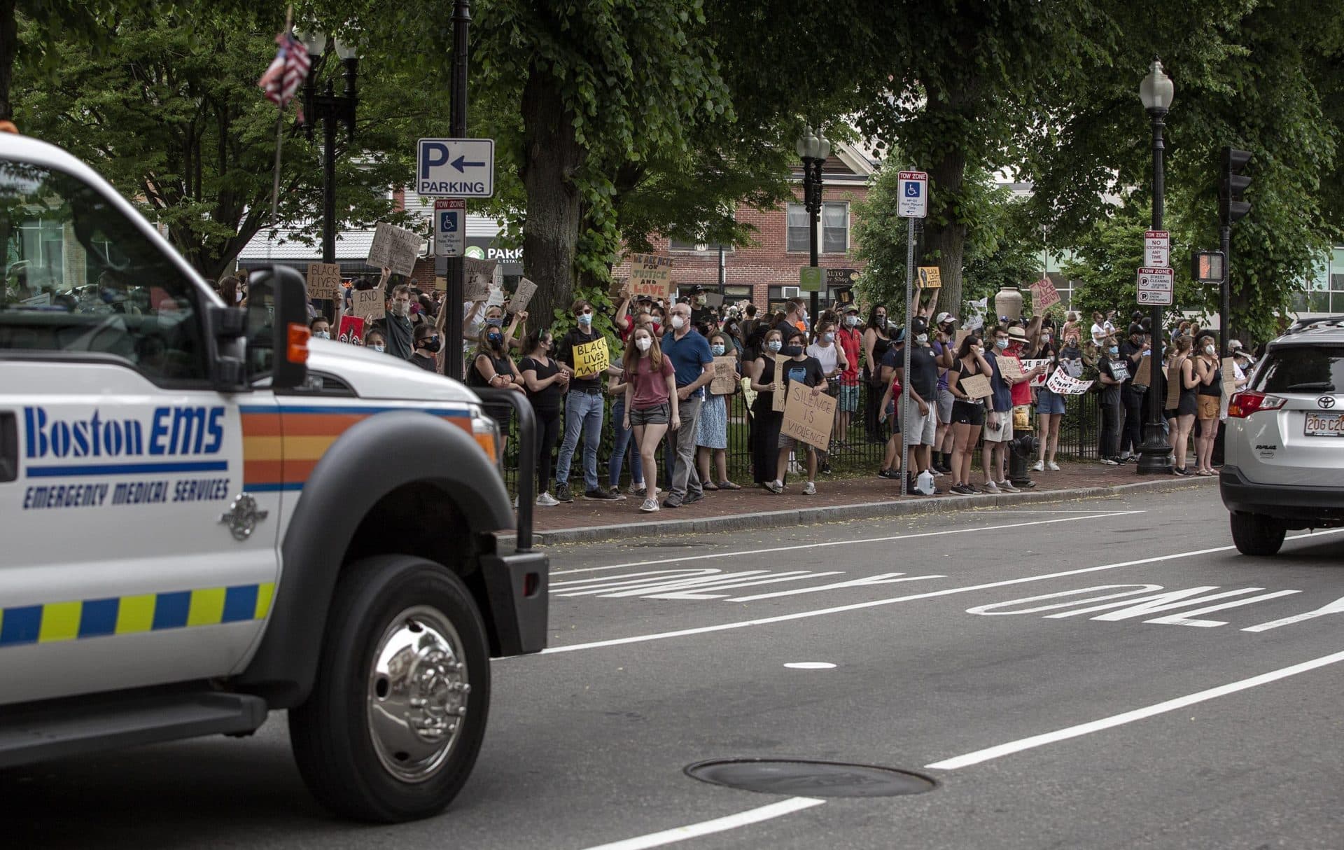 Black Lives Matter protesters line the sidewalk along Washington Street at Adams Park in Roslindale. (Robin Lubbock/WBUR)