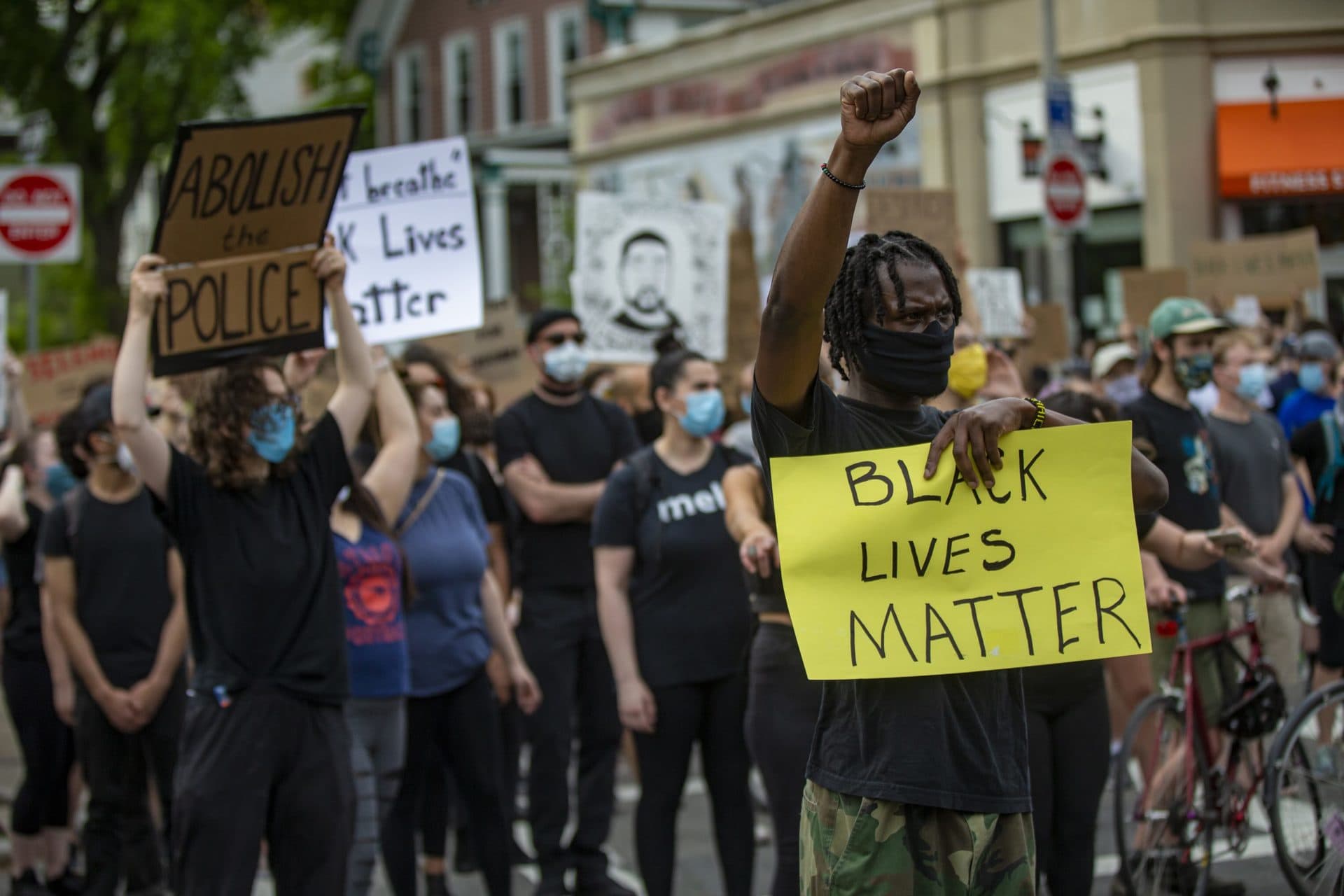 Junior Nash stands out from the crowd with his fist raised during a protest in Jamaica Plain. (Jesse Costa/WBUR)