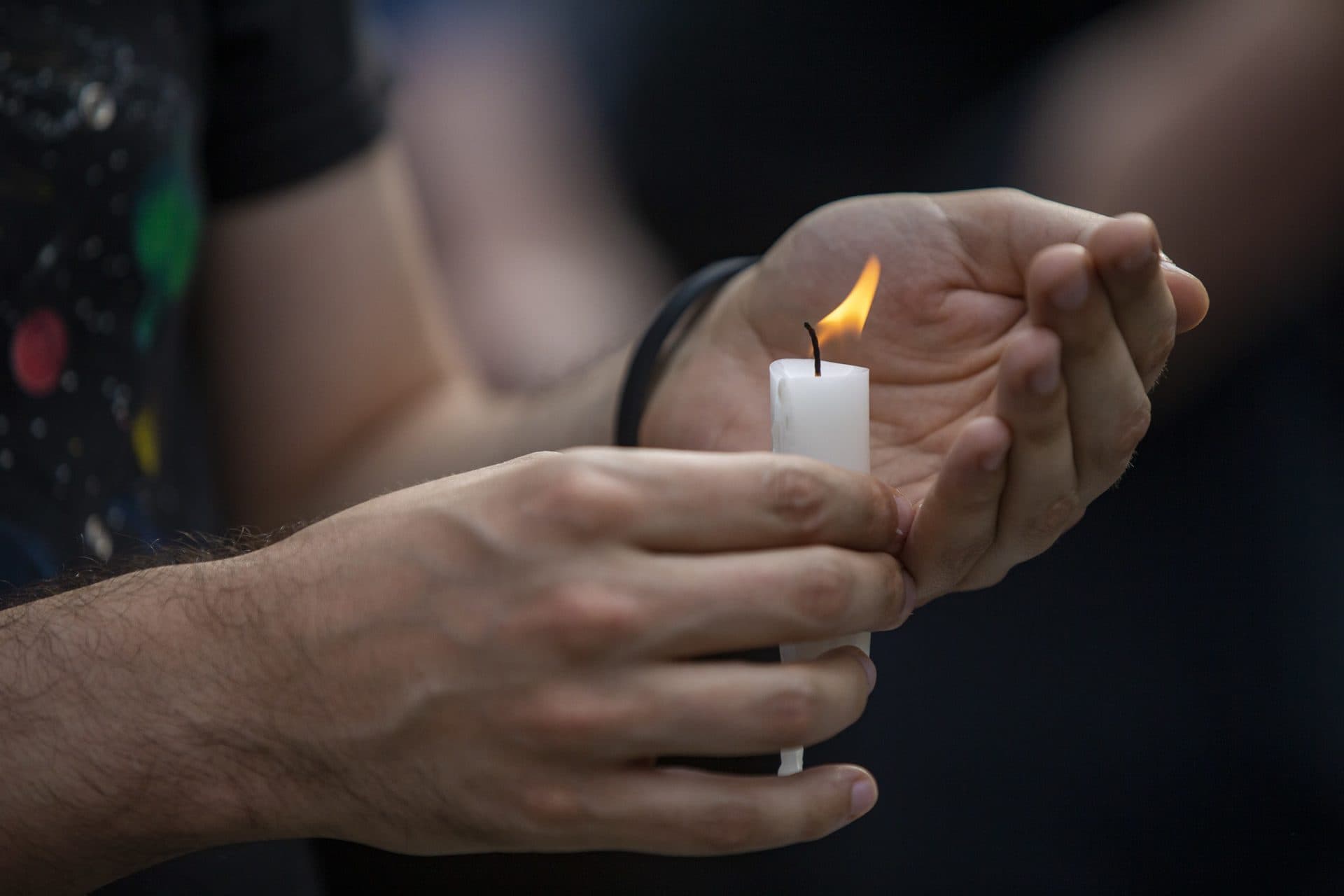 A candle is lit by a protester during the vigil in Jamaica Plain. (Jesse Costa/WBUR)