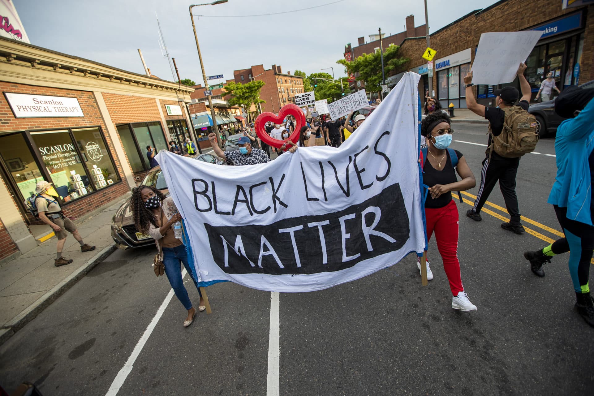 Protesters begin their march down Centre Street towards the Boston Police E-13 District station in Jamaica Plain. (Jesse Costa/WBUR)