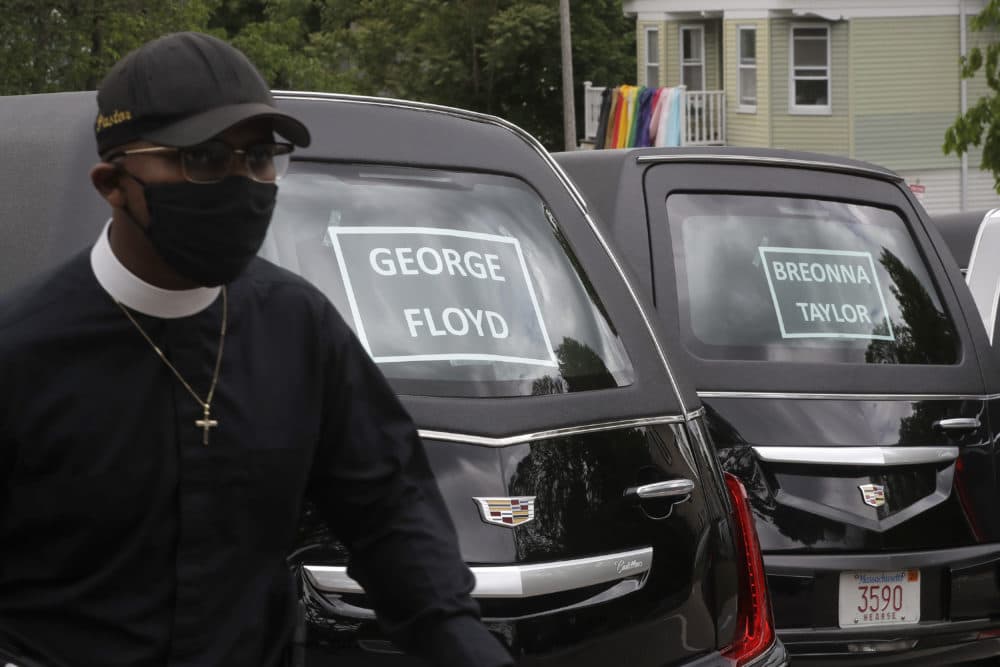 Rev. James Harrison, of the Southern Baptist Church, in Boston, walks past hearses meant to honor fallen George Floyd, Breonna Taylor, and Ahmaud Arbery, before the start of a procession through Boston. (Steven Senne/AP)