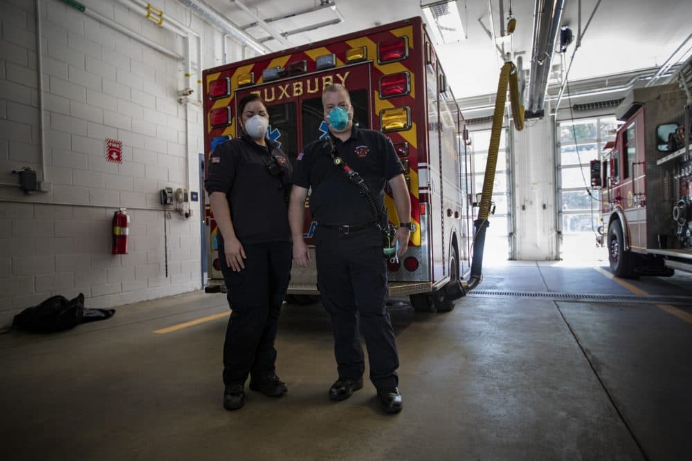 Paramedics Jen Baldock and Justin Stratton get back from a call earlier in the morning at the Duxbury Fire Department. They are wearing N95 masks that were procured from MEMA after a shipment of faulty ones were delivered to them. (Jesse Costa/WBUR)